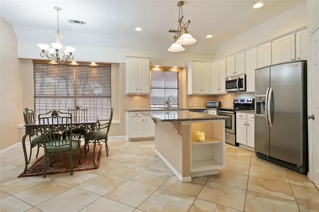 a kitchen with granite countertop white cabinets white appliances and a sink