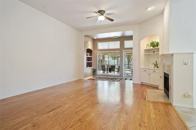 wooden floor fireplace and windows in an empty room