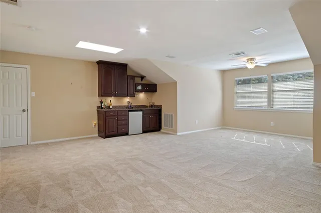 a living room with furniture a rug kitchen view and a table