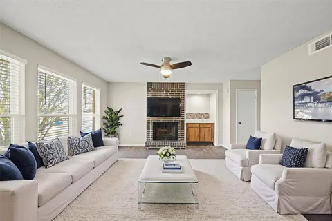 a living room with furniture a fireplace and a large window