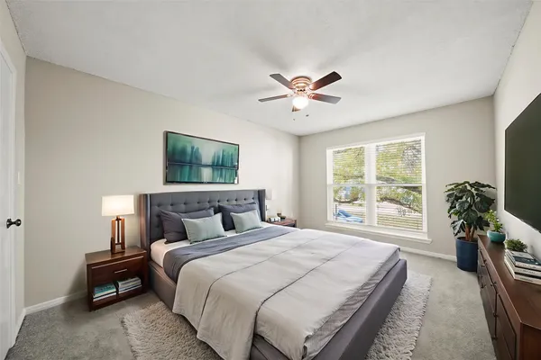 a bedroom with a large bed and a chandelier