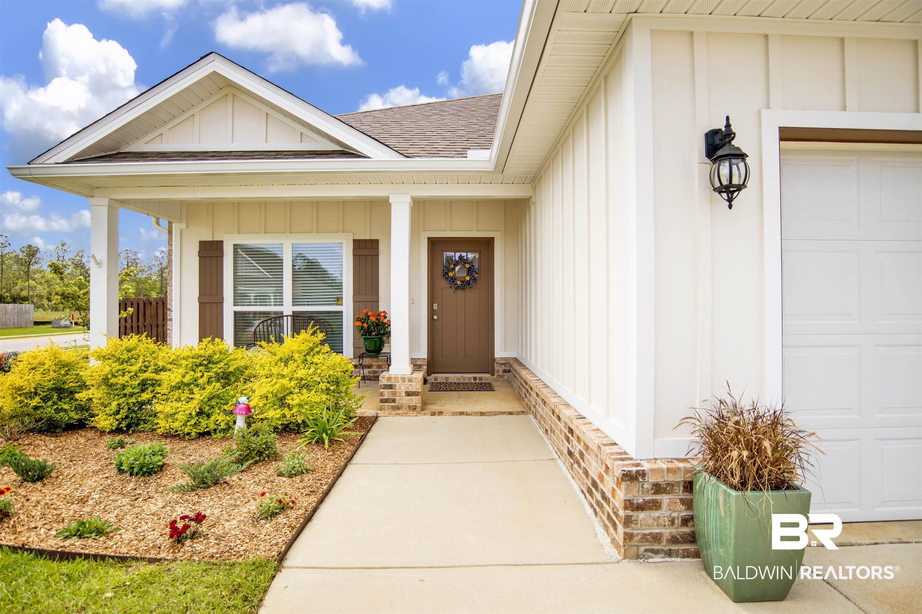 Property entrance featuring board and batten siding, a shingled roof, covered porch, and an attached garage