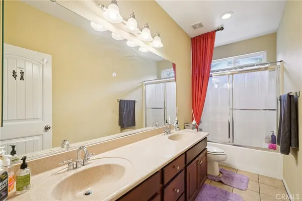 a bathroom with a double vanity sink mirror and toilet