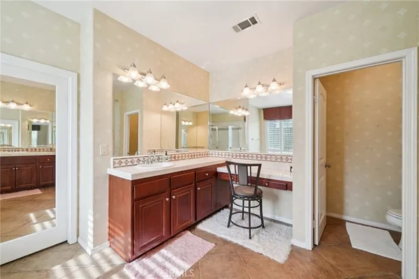 a bedroom with a bed a window and a chandelier