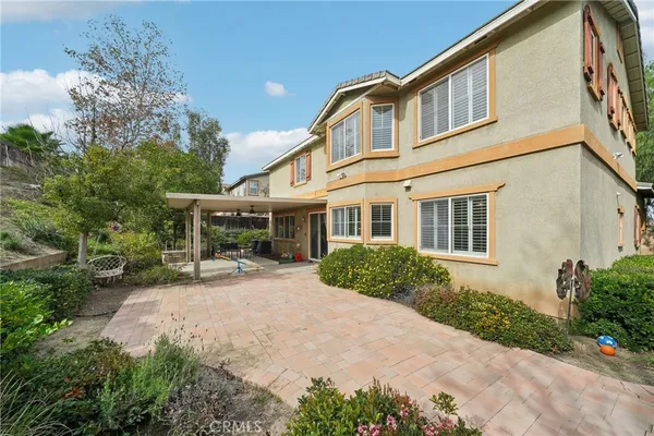 a front view of a house with a yard and potted plants