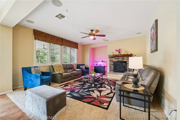 a living room with furniture a flat screen tv and a window