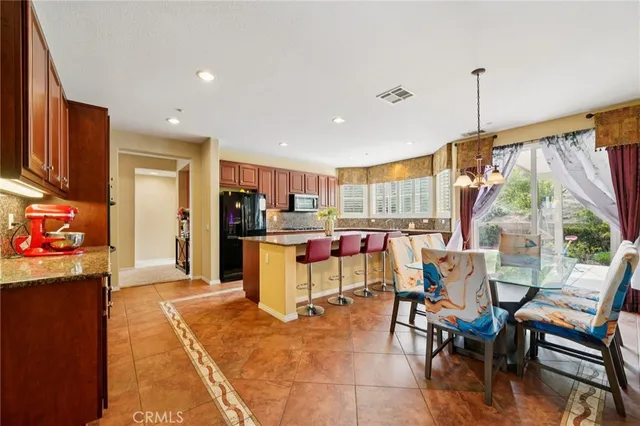 a living room with furniture a dining table and a floor to ceiling window