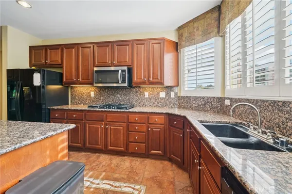 a kitchen with stainless steel appliances granite countertop a sink stove and cabinets