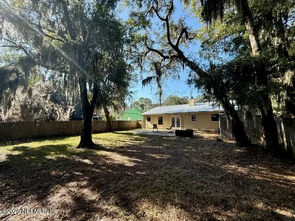a view of a house with a tree in front of it