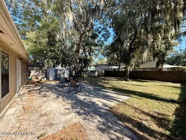a view of a yard with wooden fence