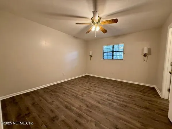 an empty room with fan and a ceiling fan