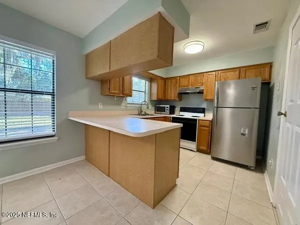 a kitchen with a sink a counter top space and stainless steel appliances