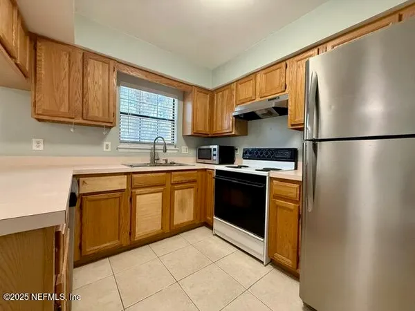 a kitchen with stainless steel appliances granite countertop a refrigerator sink and cabinets