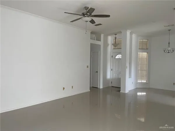 a view of a big room with chandelier fan and windows