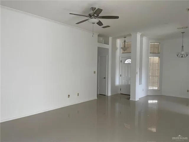 a view of a big room with chandelier fan and windows