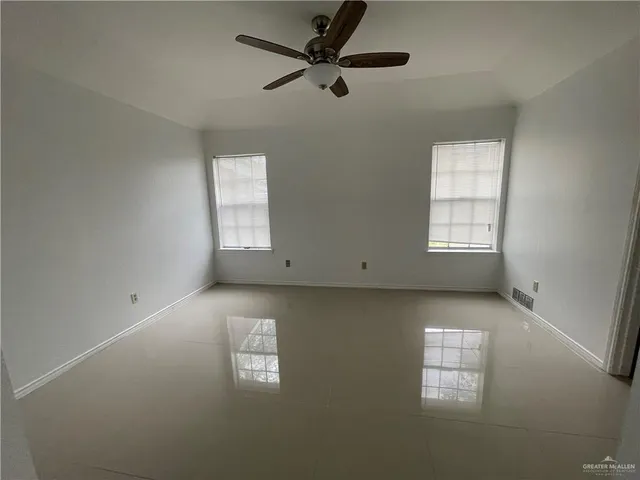 an empty room with windows and fan