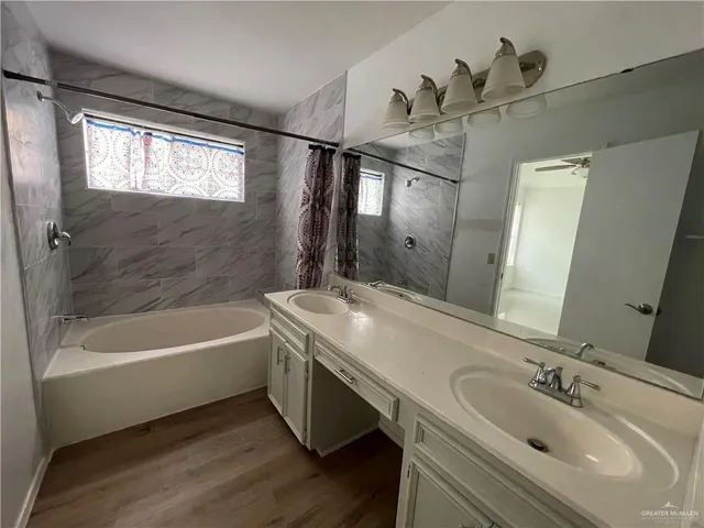 a bathroom with a tub sink and mirror