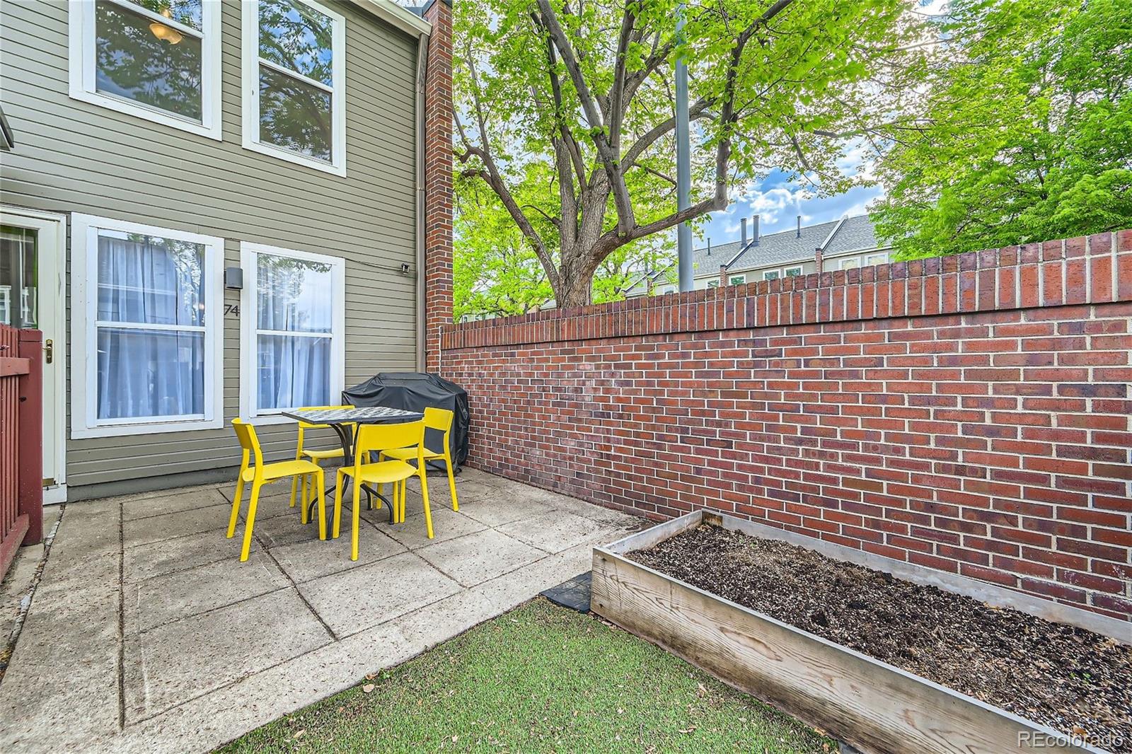 1150 Inca Street, Unit 74 Denver, CO 80204 - Photo 11 of 32 a view of a patio with a table and chairs and wooden fence