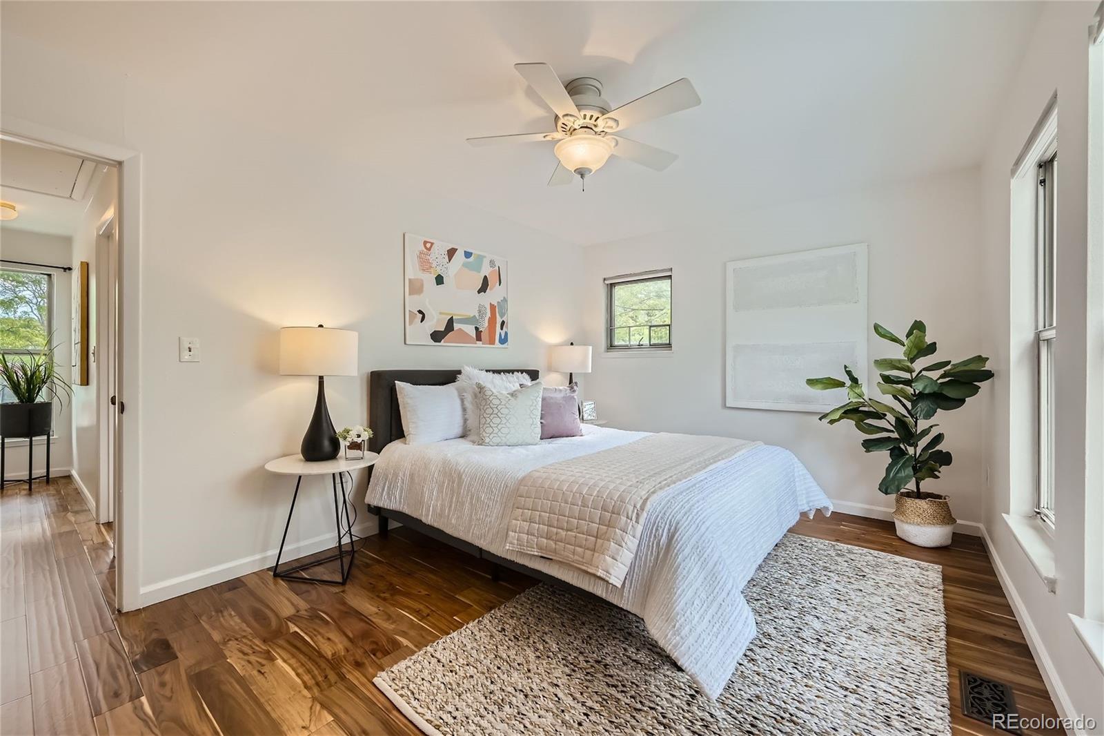 1150 Inca Street, Unit 74 Denver, CO 80204 - Photo 12 of 32 a bedroom with a large bed and a chandelier