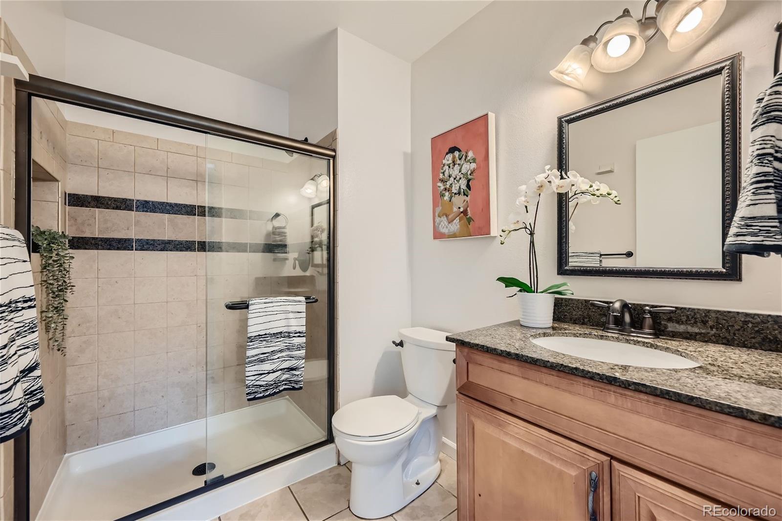 1150 Inca Street, Unit 74 Denver, CO 80204 - Photo 15 of 32 a bathroom with a granite countertop sink toilet and shower