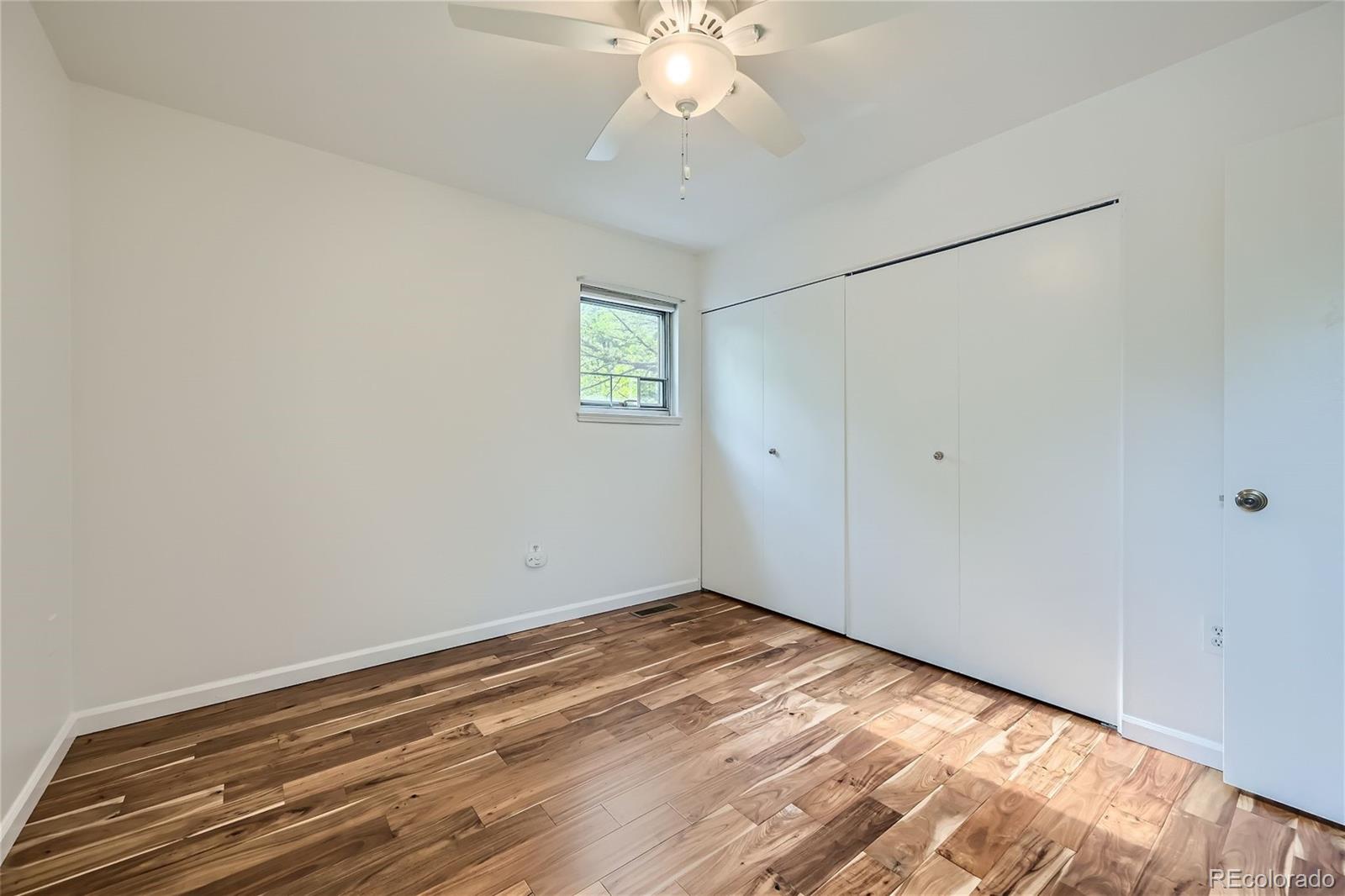 1150 Inca Street, Unit 74 Denver, CO 80204 - Photo 17 of 32 a view of a room with wooden floor and chandelier fan