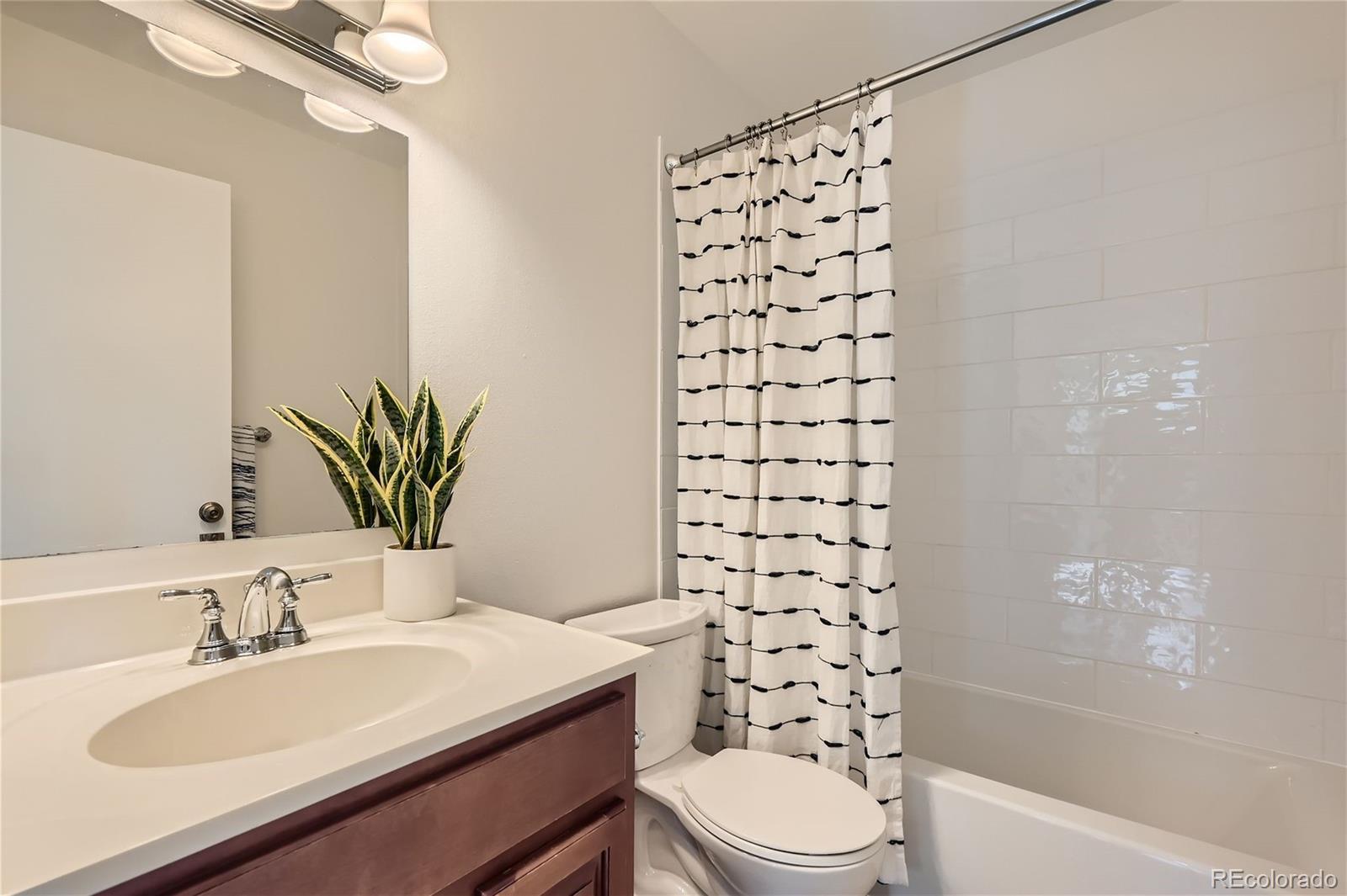 1150 Inca Street, Unit 74 Denver, CO 80204 - Photo 18 of 32 a bathroom with a sink a toilet and shower
