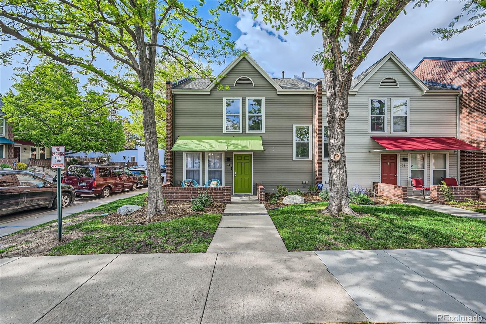 1150 Inca Street, Unit 74 Denver, CO 80204 - Photo 30 of 32 a front view of a house with a yard and garage