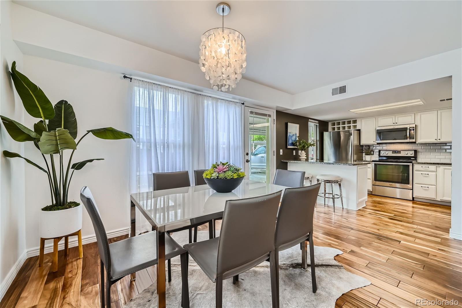 1150 Inca Street, Unit 74 Denver, CO 80204 - Photo 5 of 32 a view of a dining room with furniture and a chandelier