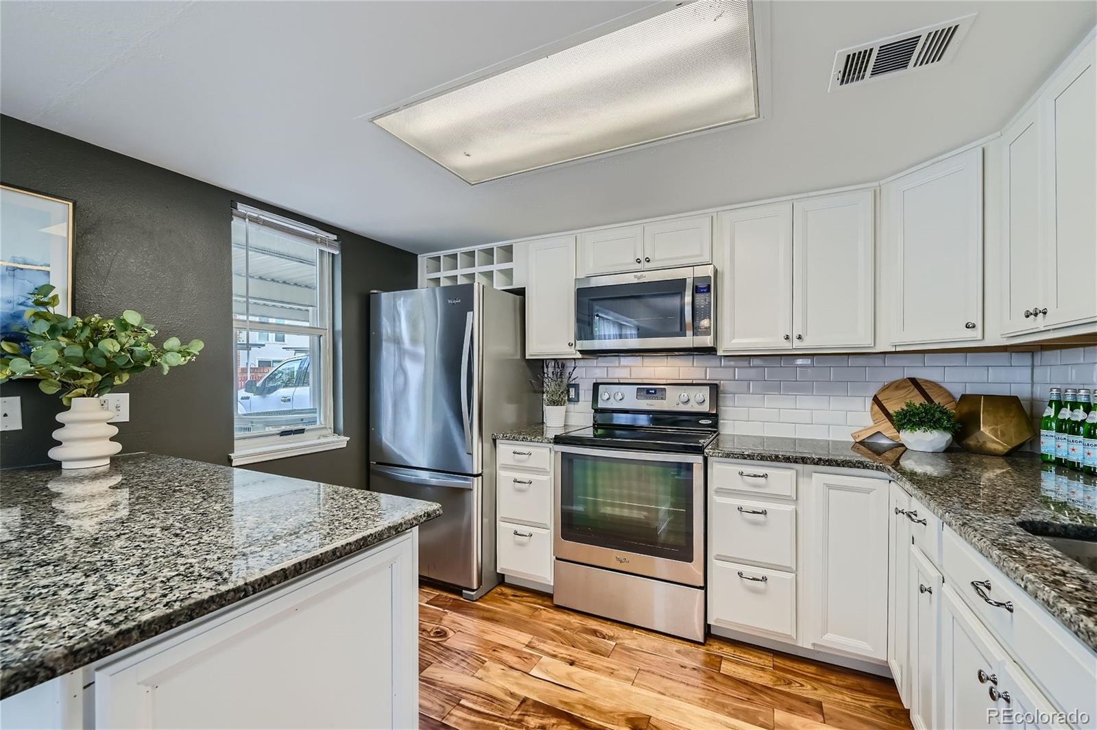 1150 Inca Street, Unit 74 Denver, CO 80204 - Photo 7 of 32 a kitchen with stainless steel appliances granite countertop a refrigerator sink and stove