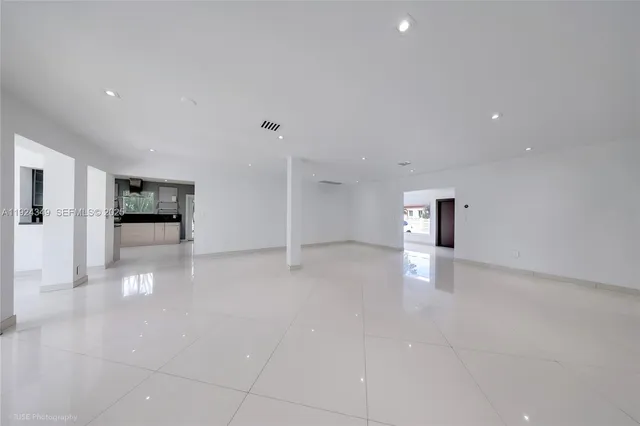 a view of a livingroom with an empty space and a refrigerator