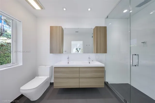a bathroom with a double vanity sink mirror and toilet