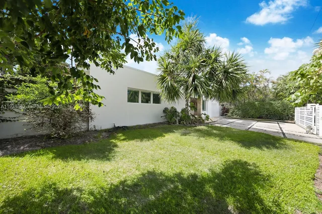 a view of backyard with swimming pool and green space