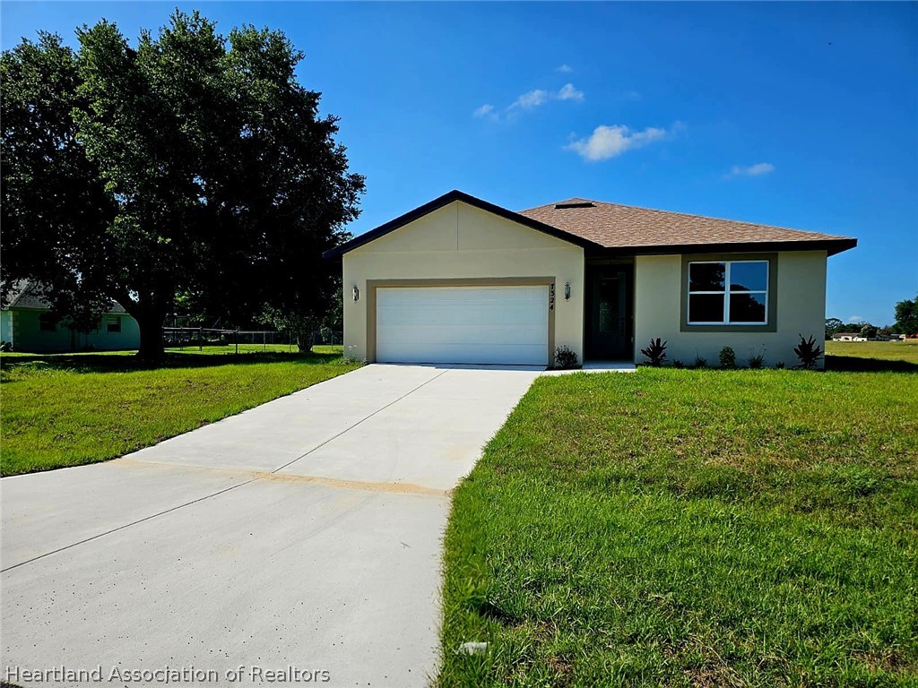 7324 Rolling Hills Road Sebring, FL 33876 - Photo 1 of 23 a front view of a house with yard and green space