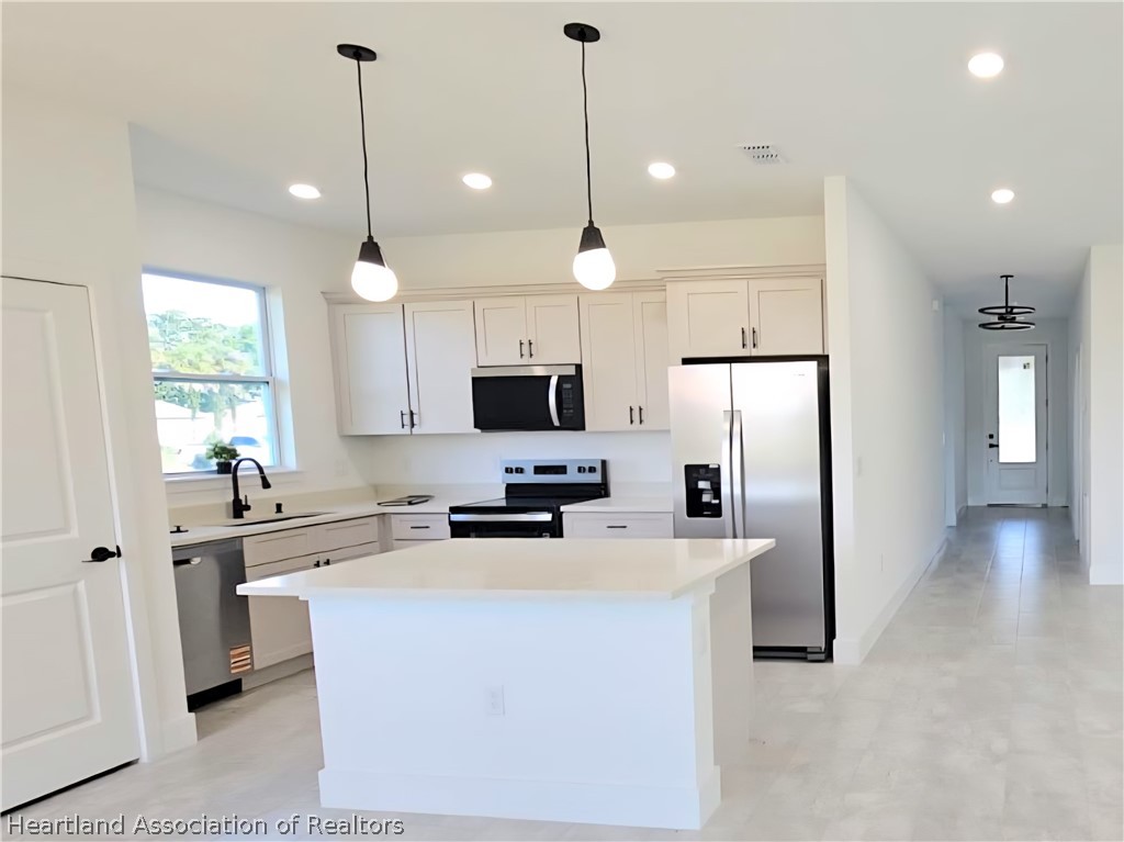 7324 Rolling Hills Road Sebring, FL 33876 - Photo 13 of 23 a kitchen with stainless steel appliances a refrigerator sink and microwave