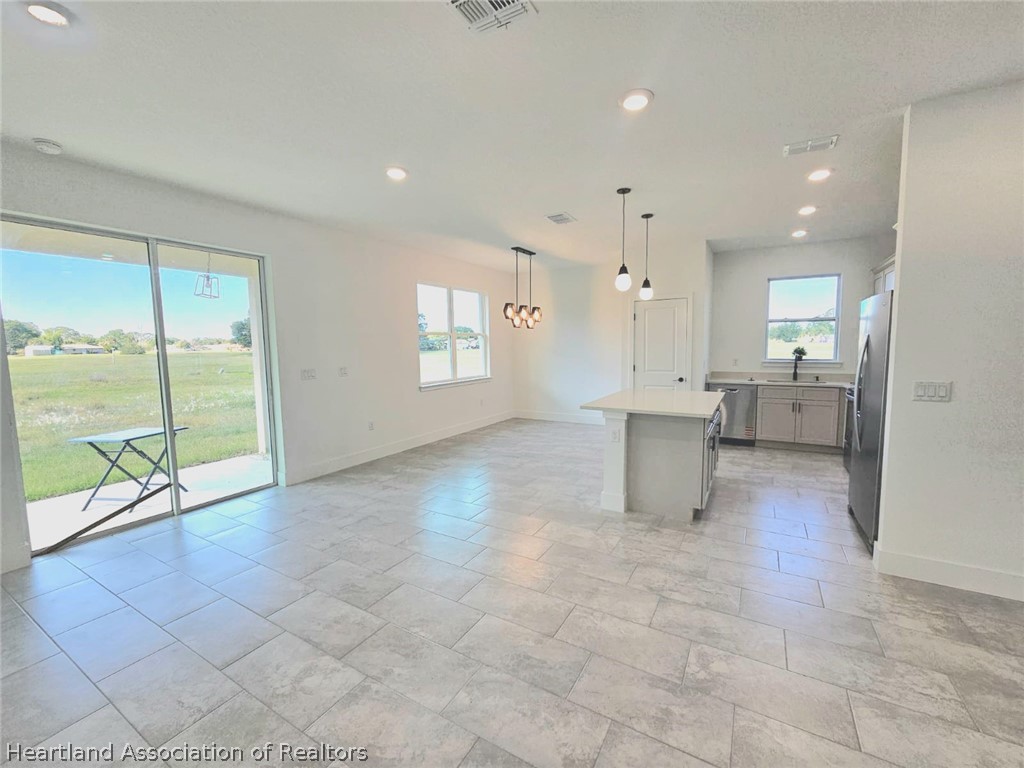 7324 Rolling Hills Road Sebring, FL 33876 - Photo 10 of 23 a view of a big room with windows and chandelier fan