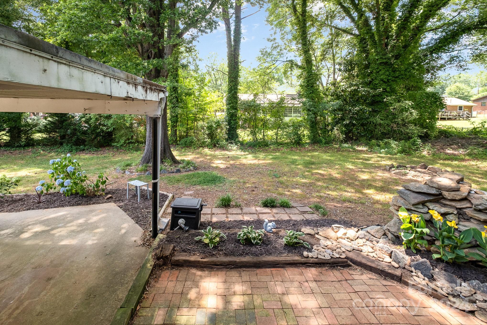4081 Section House Road Hickory, NC 28601 - Photo 32 of 38 a view of a backyard with table and chairs plants and large trees