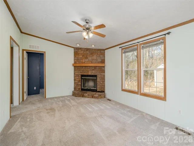 an empty room with windows and fireplace