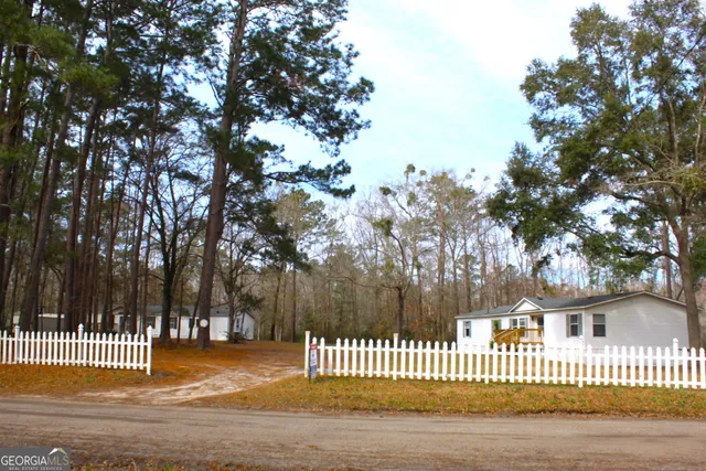 a front view of a house with a garden and tree
