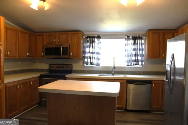 a kitchen with a sink a center island a cabinets and a window