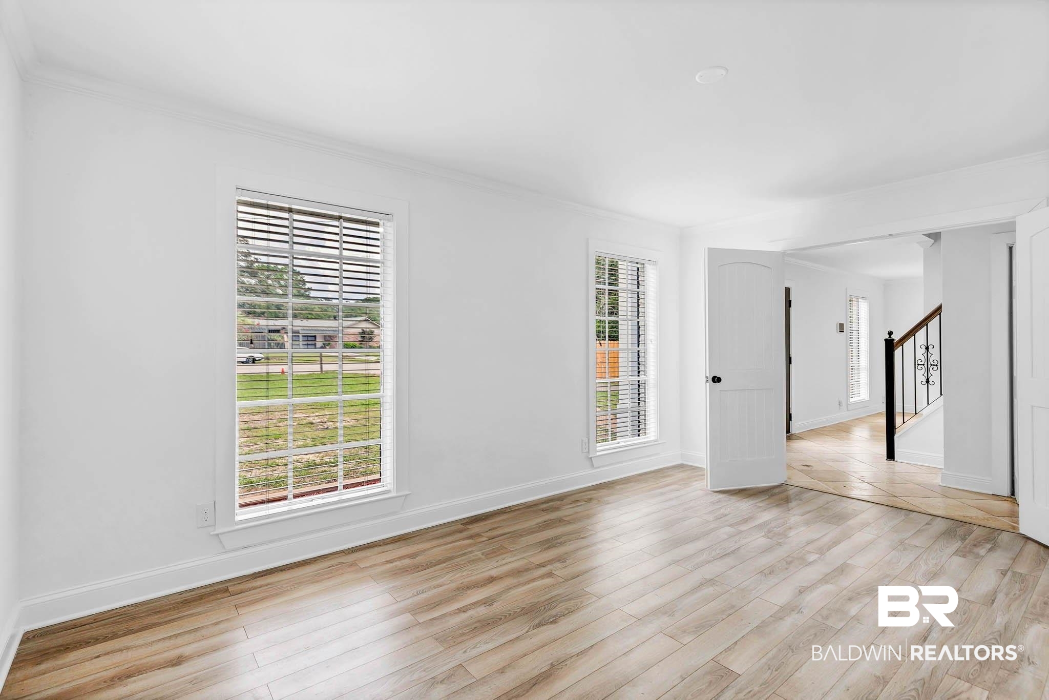 4705 Sherry Court Mobile, AL 36693 - Photo 13 of 100 Empty room featuring light wood-style floors, ornamental molding, and stairs