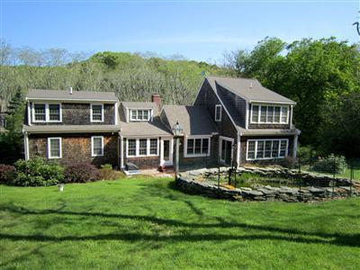 19 Higgins Hollow Road Truro, MA 02666 - Photo 1 of 34 a front view of a house with a garden and trees