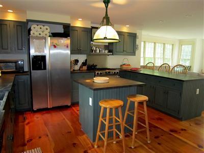 19 Higgins Hollow Road Truro, MA 02666 - Photo 12 of 34 a kitchen with granite countertop a stove a sink dishwasher a refrigerator and a dining table with wooden floor