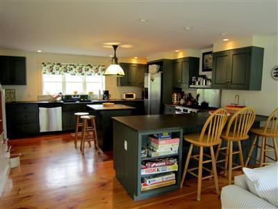 19 Higgins Hollow Road Truro, MA 02666 - Photo 13 of 34 a kitchen with stainless steel appliances granite countertop a stove top oven a sink dishwasher a dining table and chairs with wooden floor