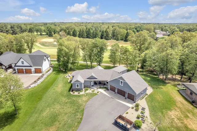 an aerial view of a house with a garden and lake view