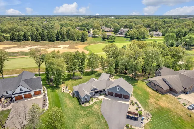 an aerial view of residential houses with outdoor space and trees