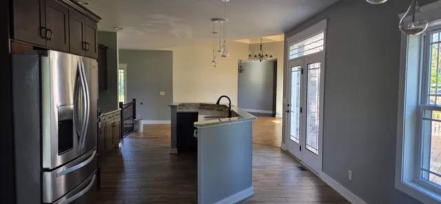 a kitchen with stainless steel appliances granite countertop a refrigerator a stove and a sink