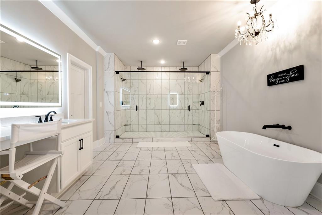 6140 Crescent Moon Ridge Cumming, GA 30041 - Photo 34 of 54 a bathroom with a bathtub sink a mirror and a shower