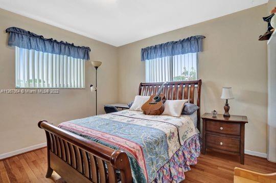5440 Buchanan Street Hollywood, FL 33021 - Photo 30 of 34 a bedroom with a bed and wooden floor