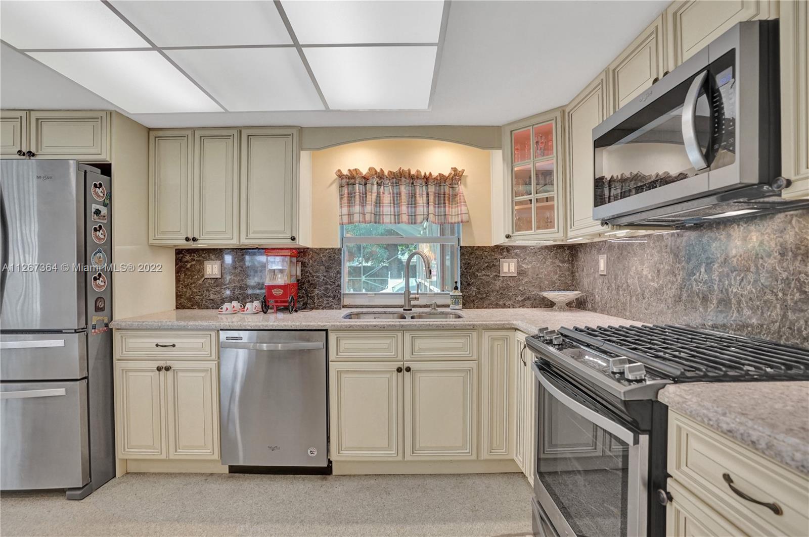5440 Buchanan Street Hollywood, FL 33021 - Photo 6 of 34 a kitchen with a stove a sink and a microwave