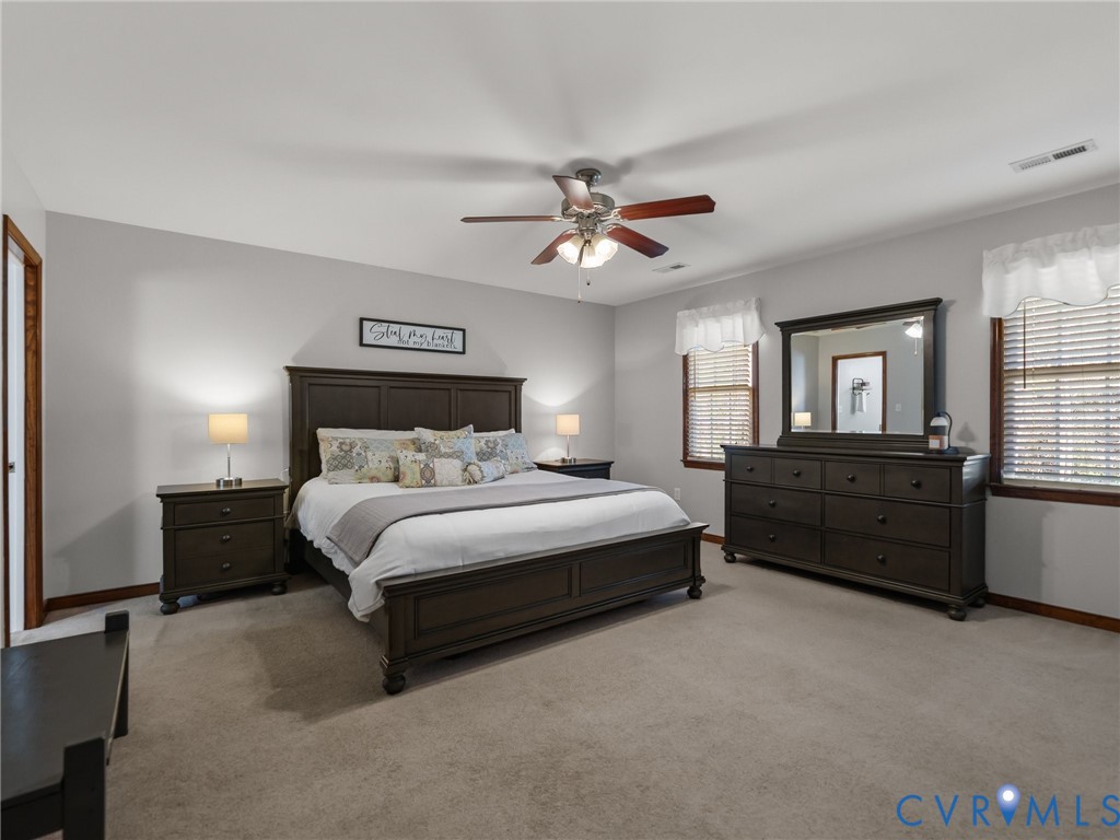 206 Rustic Drive Carson, VA 23830 - Photo 26 of 51 a spacious bedroom with a bed and a chandelier